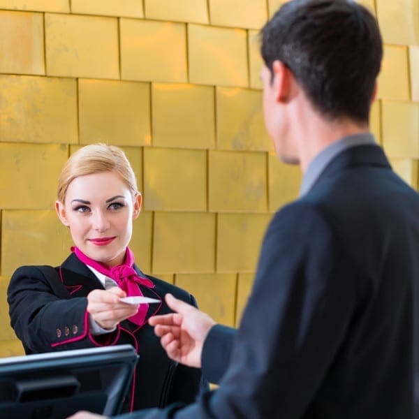 Man in Hotel check in at reception or front office being given key
